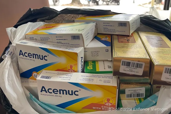 A pile of medicine boxes (Acemuc, syrups, massage oils) in a bag, before shipping.